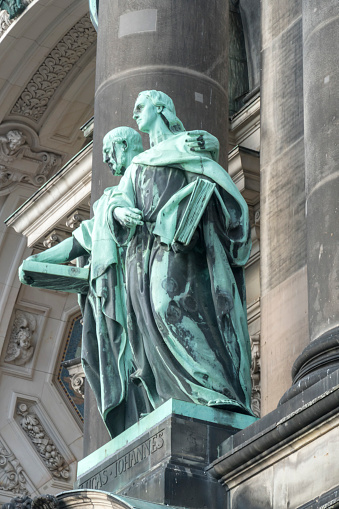 Copper statues of disciples Luke and John designed by Gerhard Janensch and Johannes Gotz on the main facade of the Berlin Cathedral, Germany