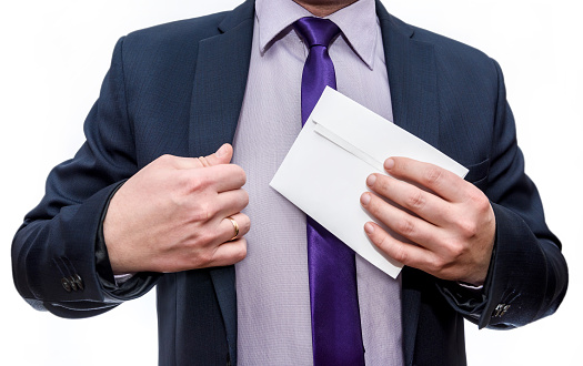 Man in suit hiding envelope into pocket