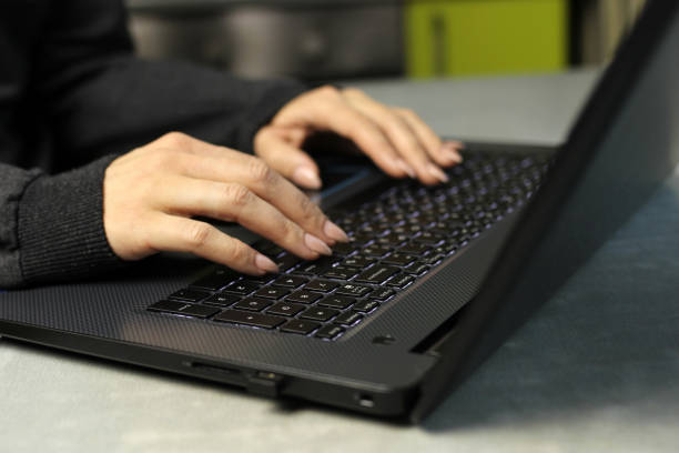 istock Young woman working on laptop on kitchen table, remote work at home, self-isolation 1221638309