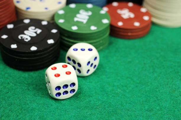 istock Casino chips and dice on a green felt table, selective focus 1221638599