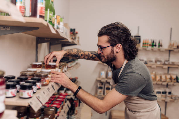 istock Young salesman arranging products on the shelf 1221639050