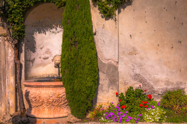 fontana di pietra in giardino idilliaco, angolo relax varenna – lago di como, italia - fountain landscaped ornamental garden flower bed foto e immagini stock
