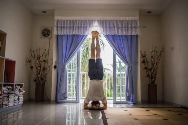 un yoga d’homme chinois d’asie dans le salon. formation à la maison en raison de la pandémie de coronavirus covid-19. - inversion yoga photos et images de collection