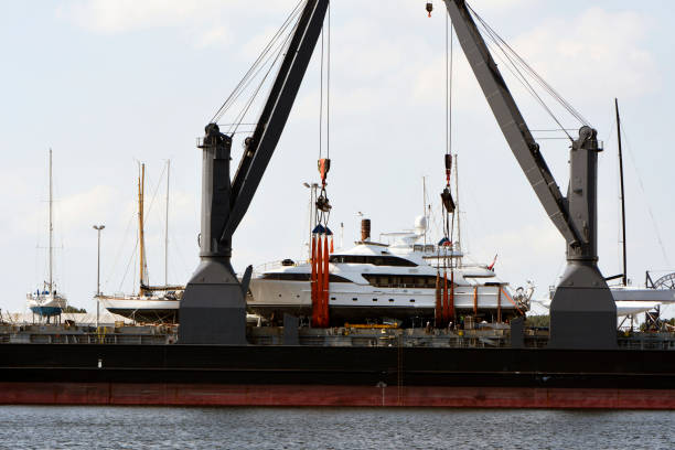 Yachts being lifted on the deck of a large carrier stock photo