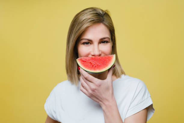 istock Woman covering mouth with a watermelon 1221642441