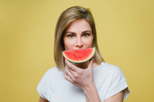 istock Woman covering mouth with a watermelon 1221642546