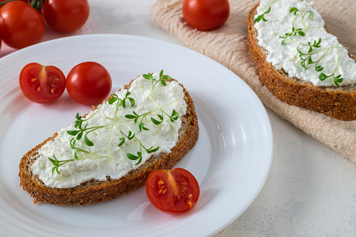 What Is Vegan Cream Cheese? Plus, Your Guide to the Best Dairy-Free Brands What Is Vegan Cream Cheese? Plus, Your Guide to the Best Dairy-Free Brands whole grain bread sandwich with cream cheese or cottage cheese microgreens and cherry tomatoes
