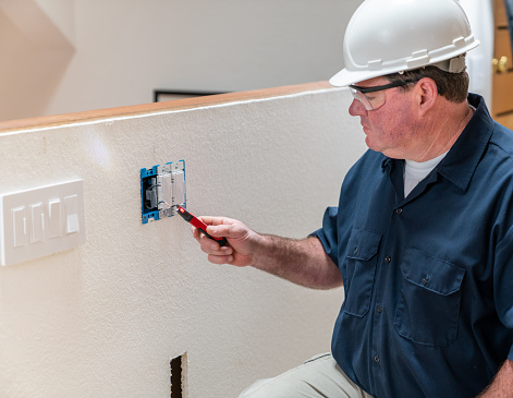 Electrician installing light switch in home