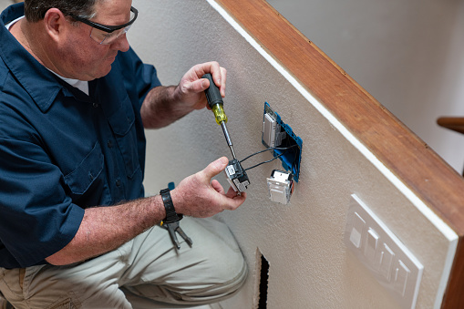 Electrician installing light switch in home