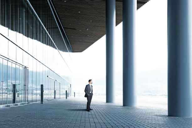 istock Businessman Wearing Mask Standing Outside Large Office Building 1221644403