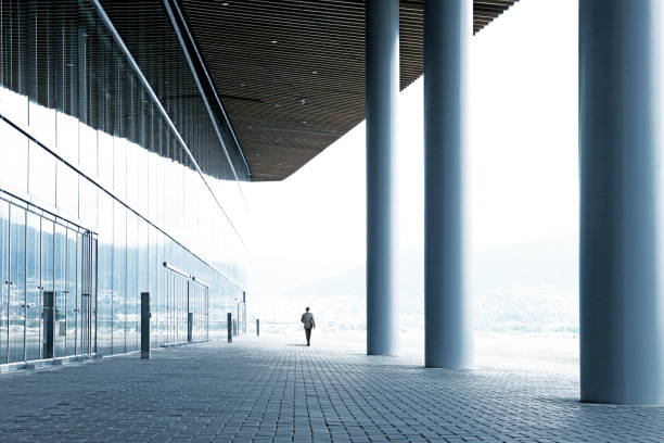 istock Lone Businessman Walking Away From Office Building 1221644408