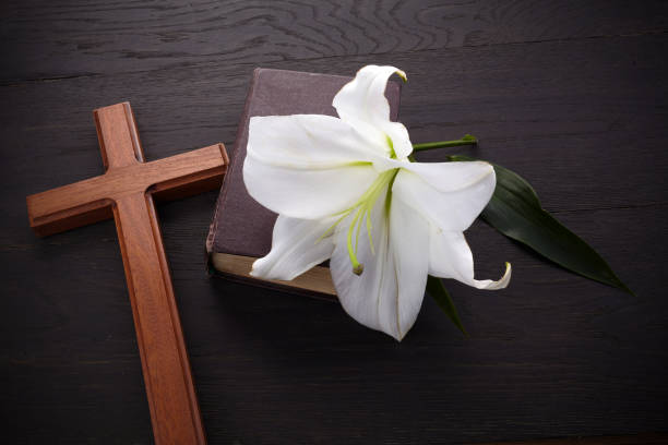 istock Wooden cross and white lily on rustic table 1221644734