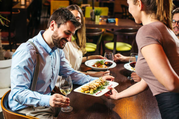 istock Young waitress serving young couple at the restaurant 1221644769