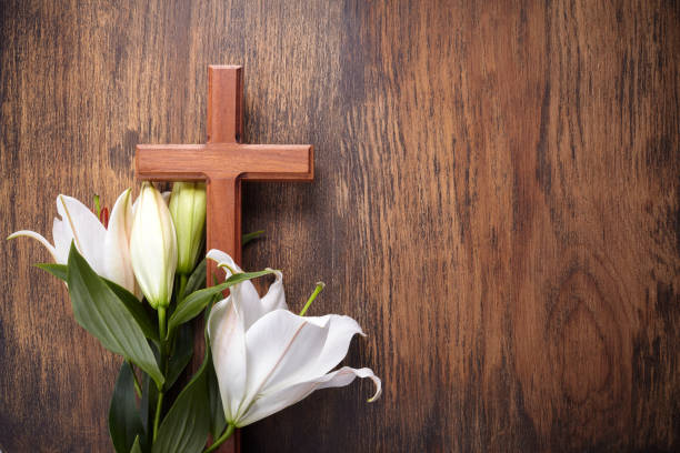 istock Wooden cross and white lily on rustic table 1221644778