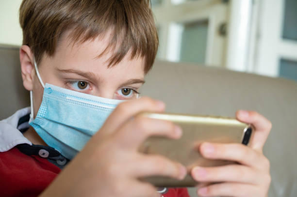 istock Boy with mask at home 1221644789