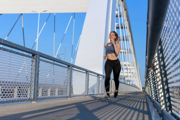 istock Girl jogging on the bridge and smiling 1221645831