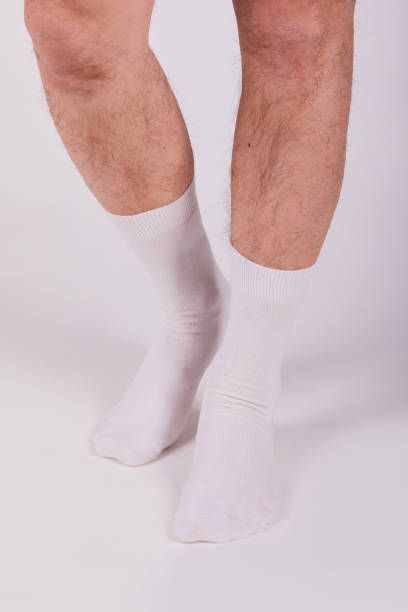 istock Man wearing new white cotton blank socks on a white background 1221645915