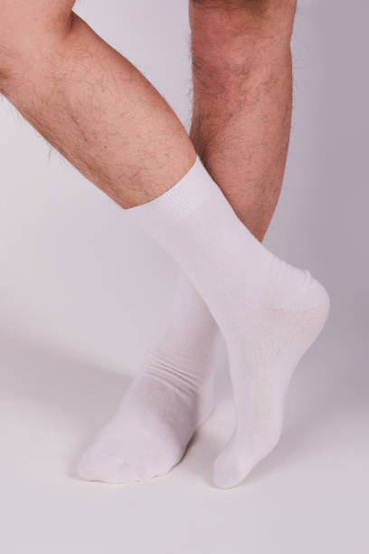 istock Man wearing new white cotton blank socks on a white background 1221645937