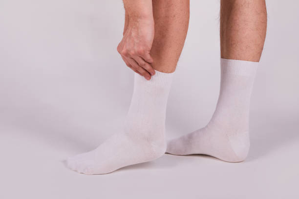 istock Man wearing new white cotton blank socks on a white background 1221646056