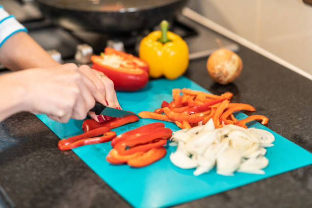 istock Woman slicing peppers in the kitchen preparing meal 1221646359