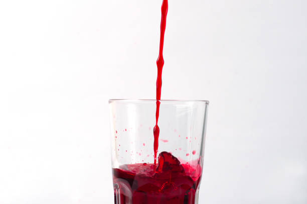 istock Grape and pomegranate juice pouring into a glass, isolate on a white background 1221646461