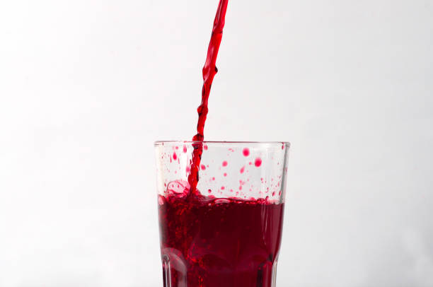 istock Grape and pomegranate juice pouring into a glass, isolate on a white background 1221646477