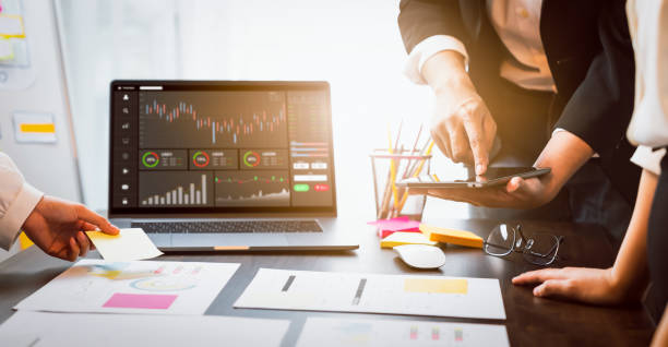 concetto di mercato in borsa, brainstorming del lavoro di squadra aziendale meeting e guardando al computer con grafici che analisino la linea di candele sul tavolo nell'ufficio notturno, diagrammi sullo schermo. - strumento di misura foto e immagini stock