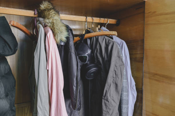 istock Open old closet in which a gas mask hangs between the clothes. Coronavirus pandemic protect yourself. 1221647308