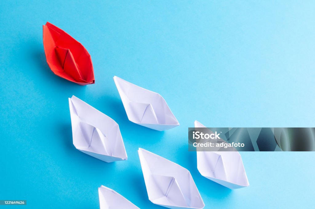 Una nave roja como líder. Blanco sándolo. Fondo azul - Foto de stock de Buque libre de derechos Una nave roja como líder. Blanco sándolo. Fondo azul - Foto de stock de Buque libre de derechos