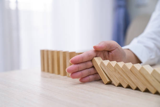istock Stopping the domino effect concept for business solution, strategy and successful intervention 1221649816