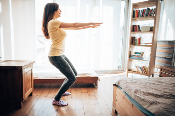 istock teenager girl doing exercise at home during the lockdown 1221649976