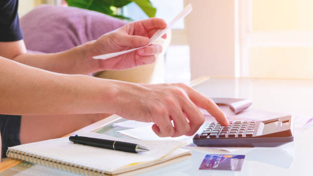 istock Selective focus of Men using calculator, holding invoice and check his salary for plan personal expense budget. Individual balance sheet for saving and payment control. Financial and economy concept. 1221650963