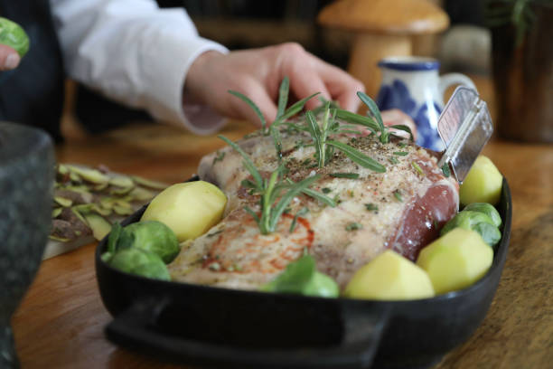 Traditional Norse Food. A chef preparing lamb with potatoes and rosemary with a pestle and mortar.