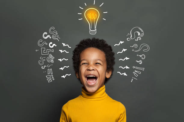 istock Ideas and brainstorm concept. Happy child school student with lightbulb and chalk question marks 1221651901
