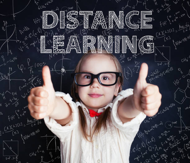 istock Happy little girl on blackboard background with math and art pattern. Distance learning and creativity education concept 1221651902