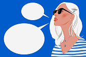istock Woman with long blond hair wearing sunglasses and empty speech bubbles 1221656350