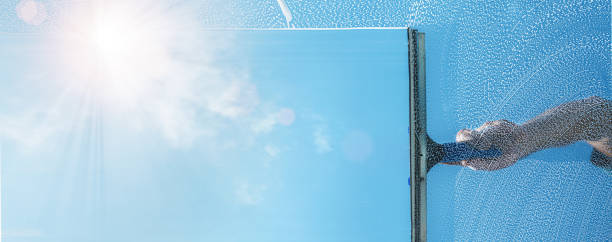 istock window cleaner cleaning window with squeegee and wiper on a sunny day 1221658715