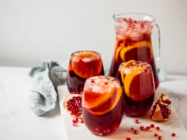 Winter sangria and christmas background, copyspace Winter sangria on tabletop with gray linen tablecloth. Jugful of sangria and glasses with with fruit slice, cranberry and rosemary. Copy space for text or design. Horizontal. Top view or flat lay. green apple slice overhead stock pictures, royalty-free photos & images