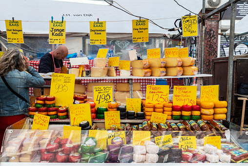 Amsterdam, Netherlands - September 8, 2018: Vendor in a cheese shop in Albert Cuyp Market, street market in Amsterdam, Netherlands