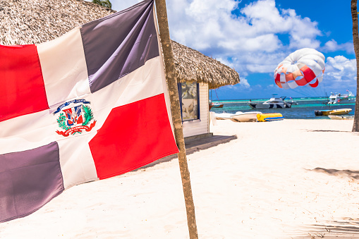 Patriotism: Dominican Republic flag in Punta Cana – Bavaro beach, Caribbean sea