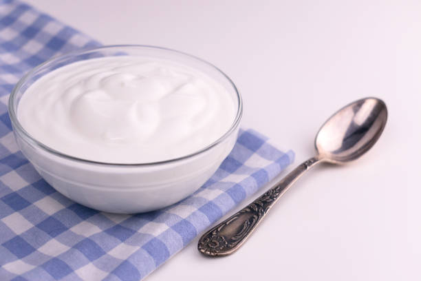 istock Greek yogurt in a glass bowl on a white table. Copy space. 1221670859