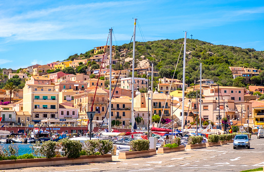 La Maddalena, Sardinia / Italy - 2019/07/17: Panoramic view of La Maddalena old town quarter with port at the Tyrrhenian Sea coastline and island mountains interior in background