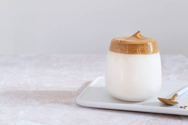 trendige koreanische dalgona kaffee auf rosa marmor tisch - snack coffee instant coffee cappuccino stock-fotos und bilder