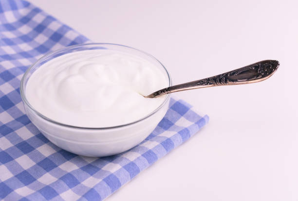 istock Greek yogurt in a glass bowl on a white table. Copy space. 1221672005