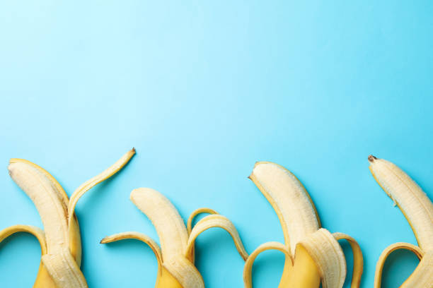 istock Opened bananas on blue background. Fresh fruit 1221674262