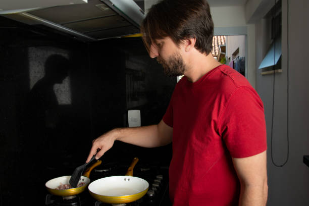 istock man cooking meat in frying pan 1221675334