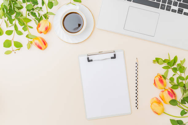 istock Flat lay blogger or freelancer workspace with a laptop, yellow tulips and branches with green leaves, office supplies on a color background 1221676795