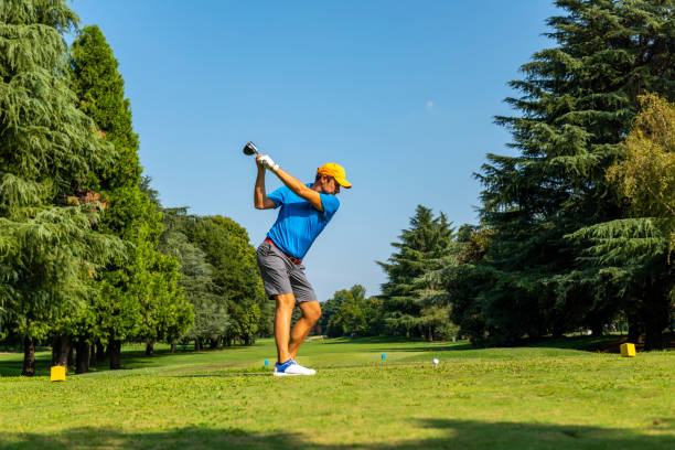 close up golfista está conduzindo bola de golfe para campo verde - golf golf swing men exercising - fotografias e filmes do acervo