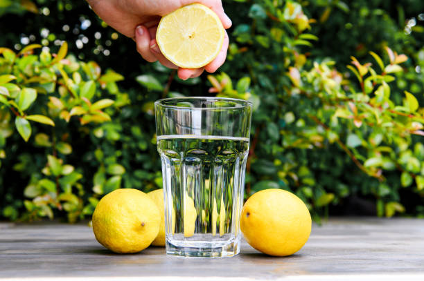 istock Squeezing a lemon into the water. Cooking lemon water. 1221682055