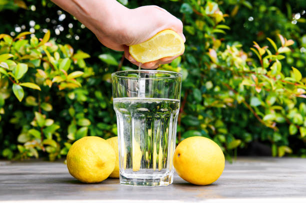 istock Squeezing a lemon into the water. Cooking lemon water. 1221682060